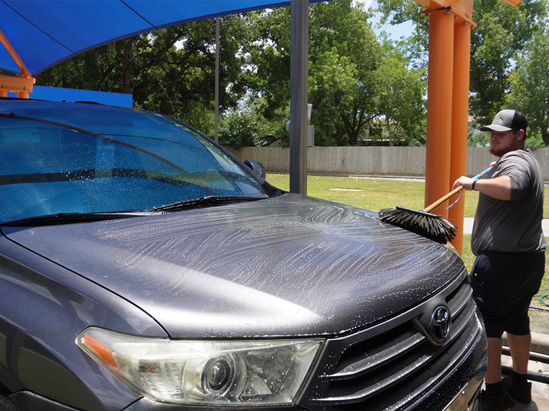 Alvin Express team member pre-washing a vehicle